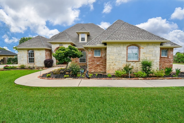 french country home featuring a front lawn