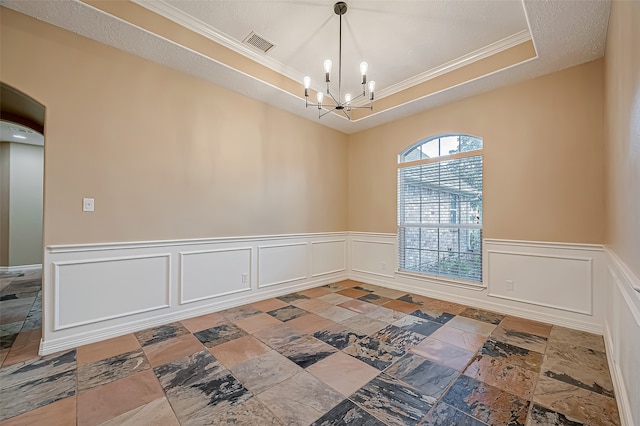 unfurnished room featuring crown molding, a raised ceiling, and a chandelier