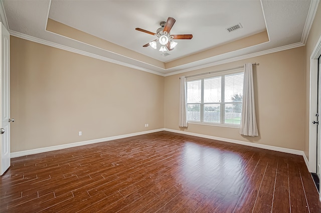 spare room with crown molding, a raised ceiling, dark hardwood / wood-style flooring, and ceiling fan