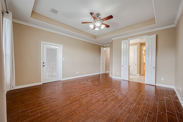 unfurnished room with crown molding, wood-type flooring, a tray ceiling, and ceiling fan