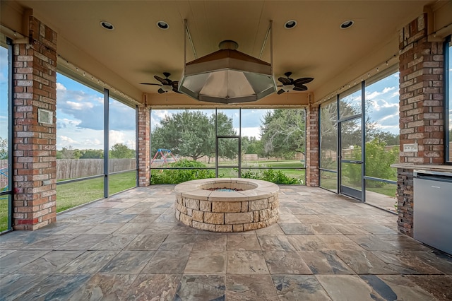 unfurnished sunroom with ceiling fan and plenty of natural light