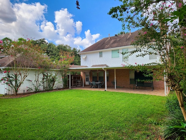 rear view of property with a yard and a patio area