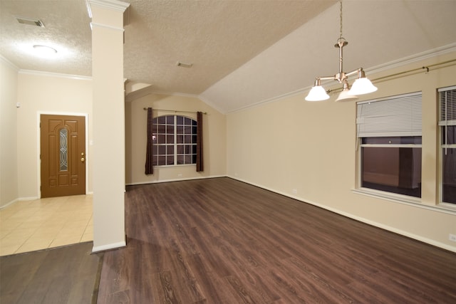 unfurnished living room featuring ornate columns, a textured ceiling, crown molding, lofted ceiling, and hardwood / wood-style floors