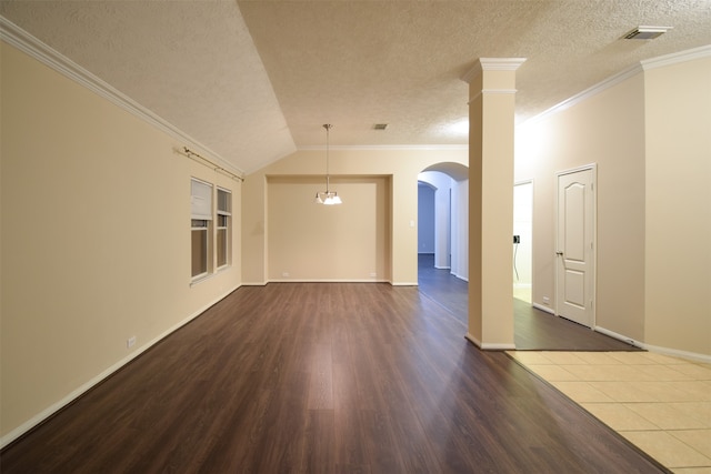 unfurnished living room with ornamental molding, a textured ceiling, lofted ceiling, and dark wood-type flooring