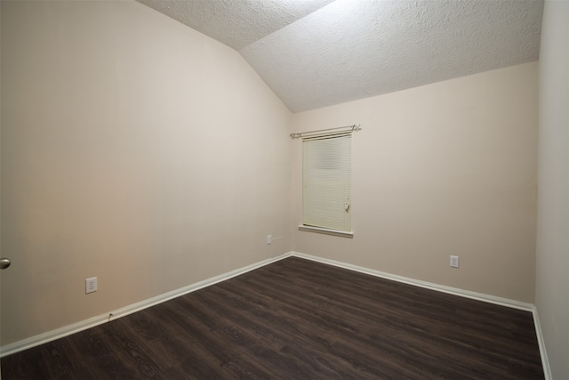 spare room featuring a textured ceiling, vaulted ceiling, and dark hardwood / wood-style floors