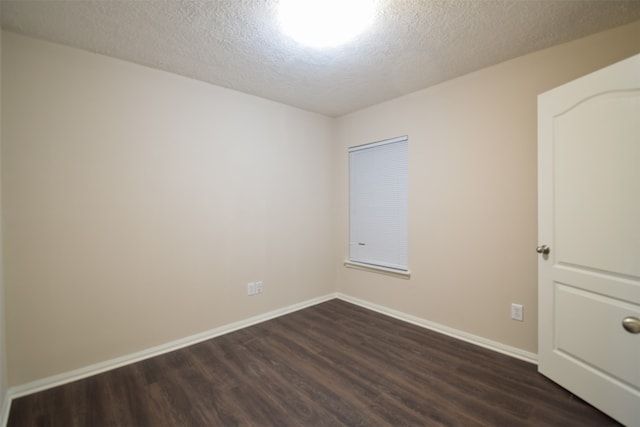 unfurnished room with a textured ceiling and dark hardwood / wood-style flooring