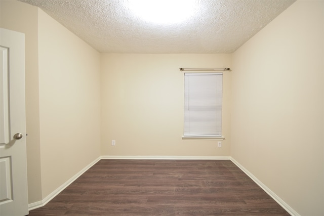 unfurnished room with a textured ceiling and dark wood-type flooring