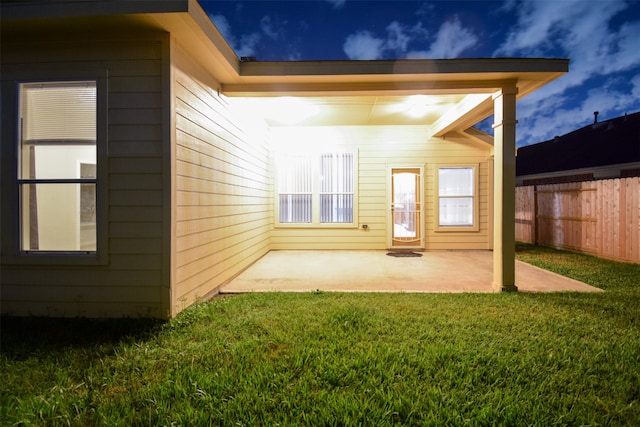 back of property with a yard and a patio