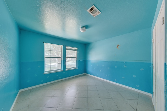 unfurnished room with a textured ceiling