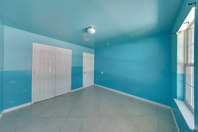 unfurnished bedroom featuring light tile patterned flooring and a closet