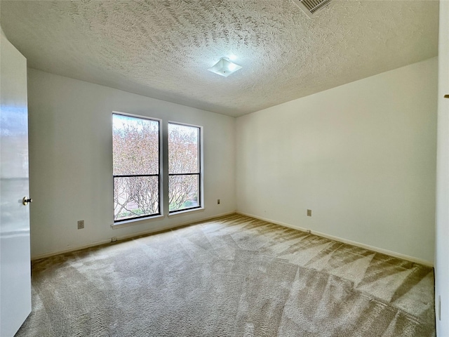 unfurnished room with light carpet and a textured ceiling