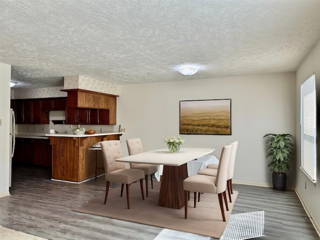 dining room with hardwood / wood-style floors and a textured ceiling