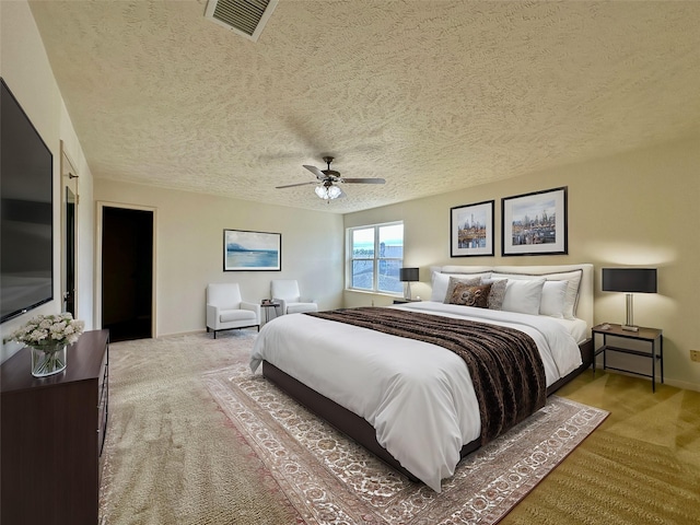 carpeted bedroom featuring a textured ceiling and ceiling fan