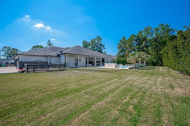 rear view of house featuring a yard and a patio