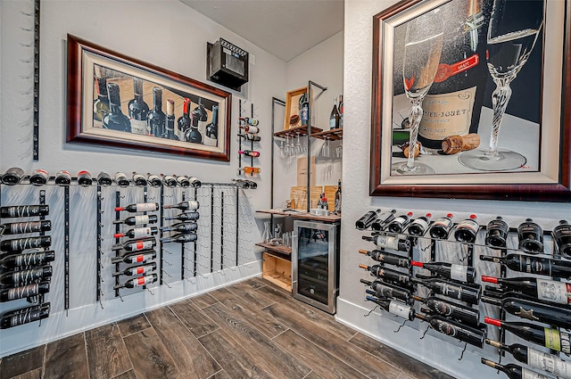 wine area featuring dark hardwood / wood-style flooring and beverage cooler