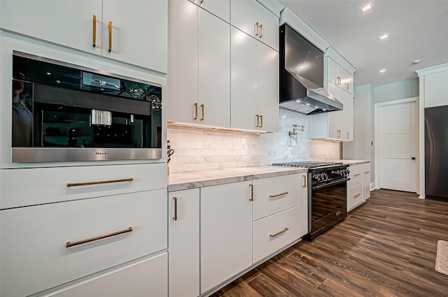 kitchen featuring wall chimney exhaust hood, fridge, high end black range, and white cabinets