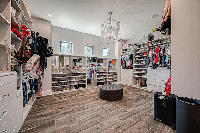 walk in closet featuring a chandelier and dark hardwood / wood-style flooring