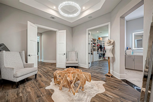 living area featuring a raised ceiling and dark hardwood / wood-style floors