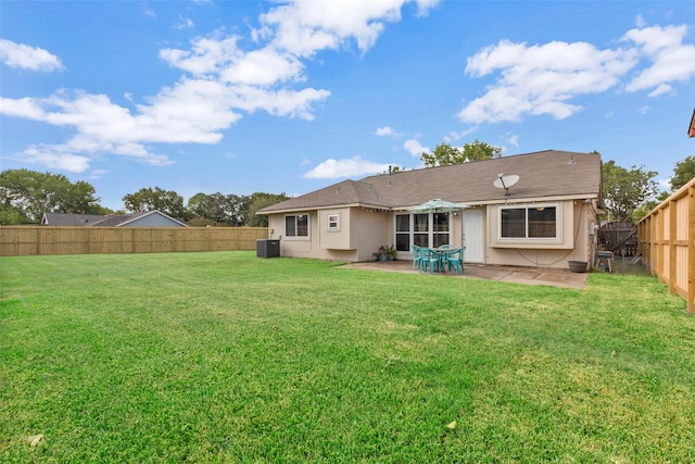 rear view of property with a lawn, cooling unit, and a patio area