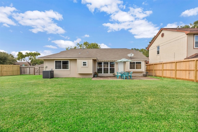 rear view of property with a lawn, cooling unit, and a patio area