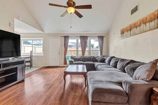 living room with ceiling fan, hardwood / wood-style flooring, and high vaulted ceiling