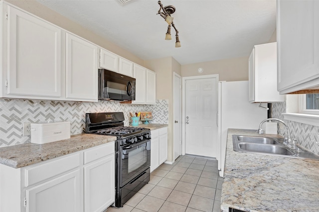 kitchen with light tile patterned floors, sink, tasteful backsplash, white cabinetry, and black appliances