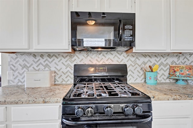 kitchen featuring light stone counters, white cabinets, decorative backsplash, and black appliances