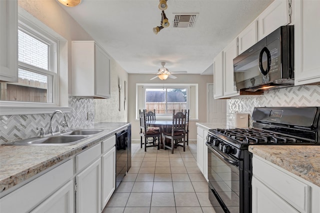 kitchen with light tile patterned floors, white cabinets, sink, and black appliances