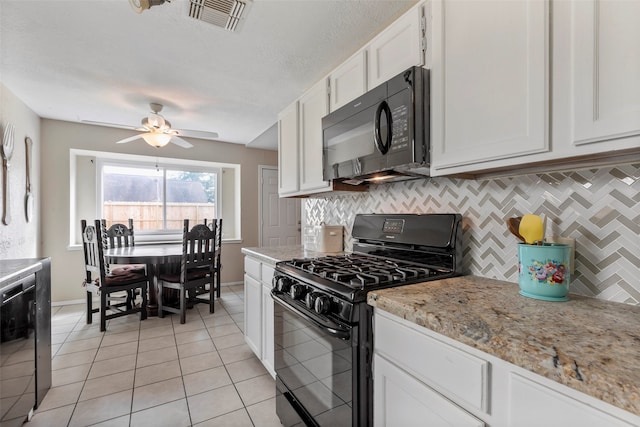 kitchen featuring light stone countertops, white cabinets, black appliances, and backsplash