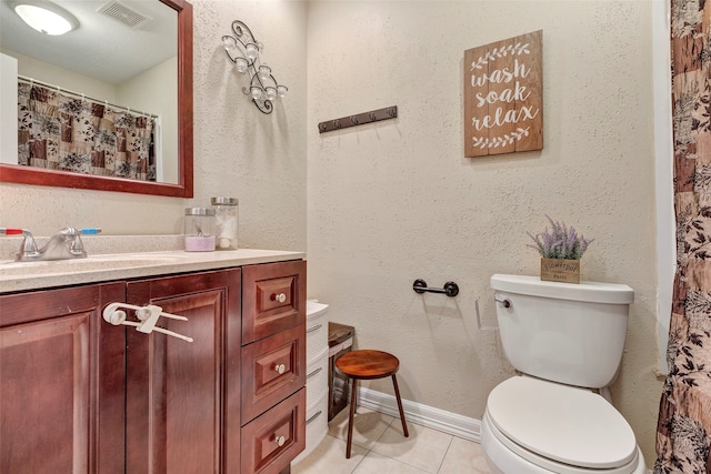 bathroom with vanity, toilet, and tile patterned floors