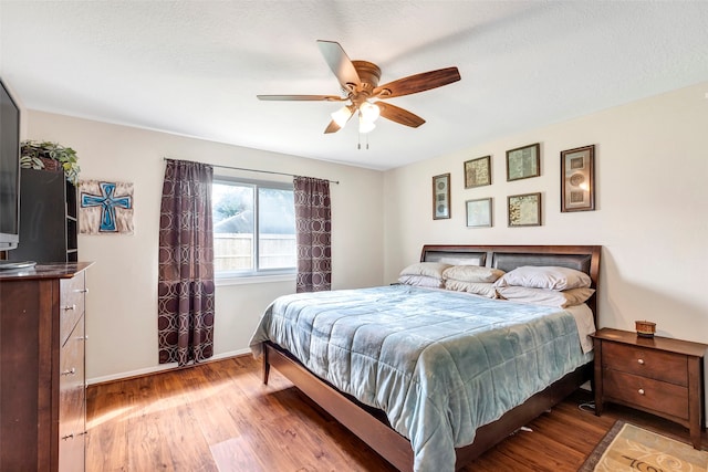 bedroom with wood-type flooring, ceiling fan, and a textured ceiling