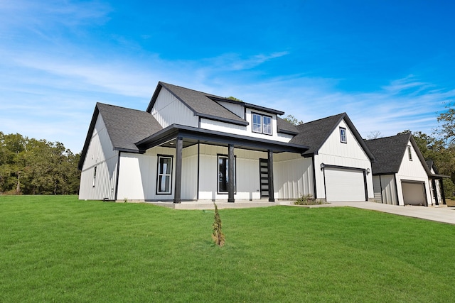 modern farmhouse featuring a garage, a porch, and a front lawn