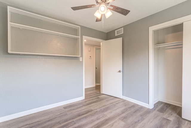 unfurnished bedroom featuring a closet, light wood-type flooring, and ceiling fan