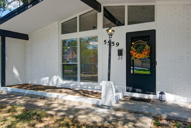 view of exterior entry with brick siding