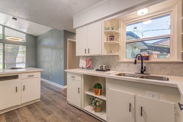 kitchen with tasteful backsplash, white cabinets, decorative light fixtures, dark hardwood / wood-style floors, and sink