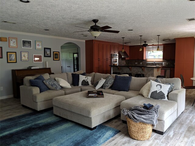 9614 Greenwillow St, Houston, TX 77096 - living room with ceiling fan, arched walkways, wood finished floors, ornamental molding, and a textured ceiling
