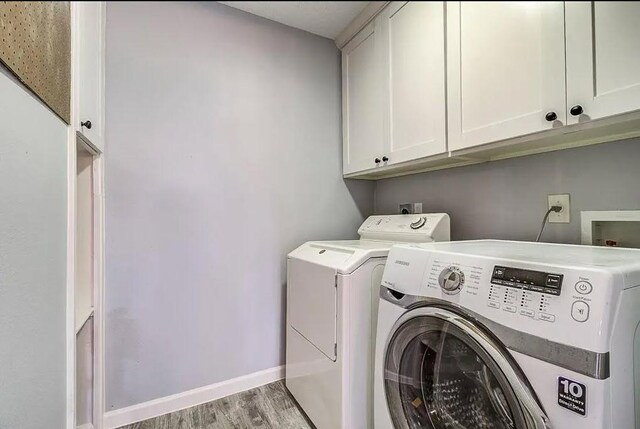 9614 Greenwillow St, Houston, TX 77096 - laundry area featuring cabinet space, light wood-type flooring, separate washer and dryer, and baseboards