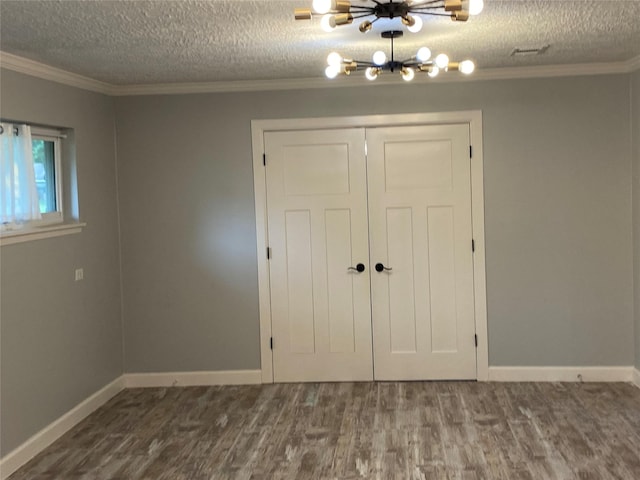 9614 Greenwillow St, Houston, TX 77096 - unfurnished bedroom with ornamental molding, dark wood finished floors, a textured ceiling, a chandelier, and a closet