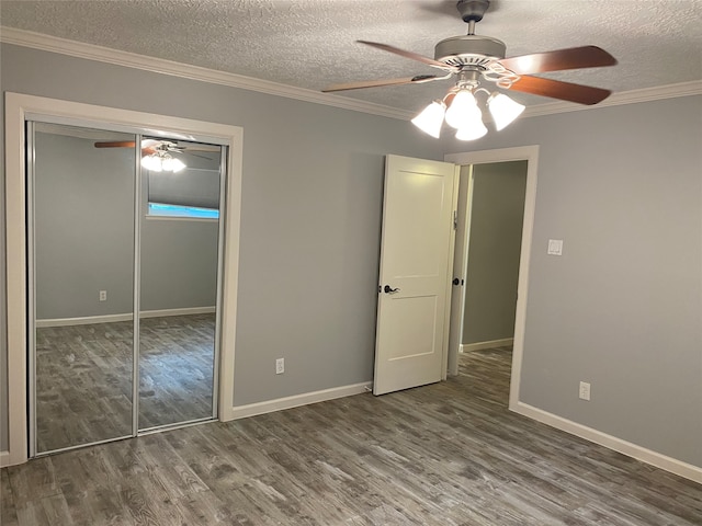 unfurnished bedroom featuring a closet, a textured ceiling, hardwood / wood-style floors, ornamental molding, and ceiling fan