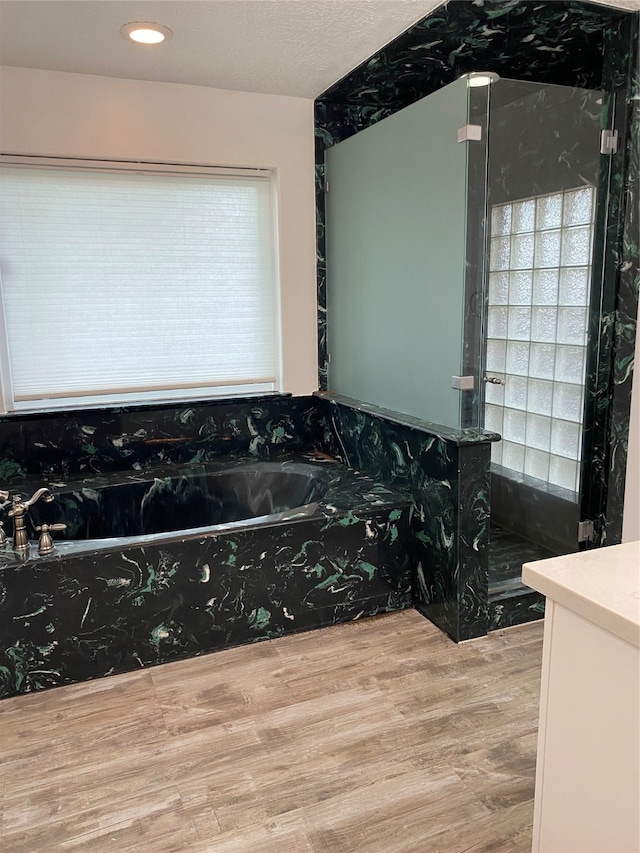 bathroom with vanity, plus walk in shower, and hardwood / wood-style floors