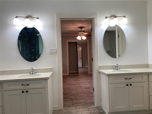 9614 Greenwillow St, Houston, TX 77096 - bathroom featuring two vanities, ceiling fan, wood finished floors, and baseboards