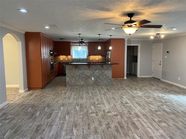 9614 Greenwillow St, Houston, TX 77096 - kitchen with a ceiling fan, stainless steel appliances, dark countertops, light wood-style flooring, and arched walkways