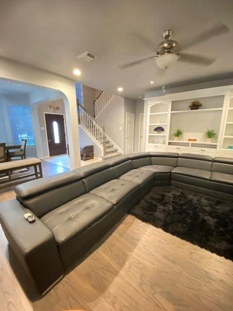 19603 Huckleberry Branch Ct, Spring, TX 77388 - living area featuring a ceiling fan, arched walkways, wood finished floors, stairway, and built in features