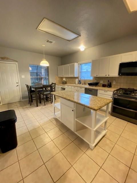 19603 Huckleberry Branch Ct, Spring, TX 77388 - kitchen featuring open shelves, double oven range, black microwave, white cabinets, and light tile patterned flooring