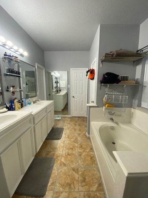 bathroom featuring a textured ceiling, a bathing tub, and vanity