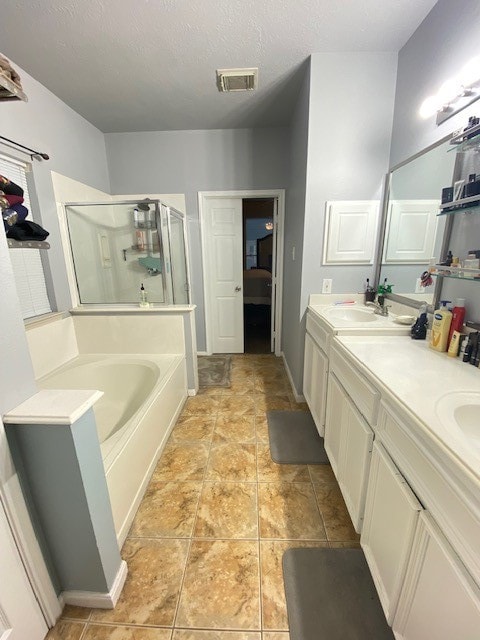 bathroom with shower with separate bathtub, a textured ceiling, and vanity