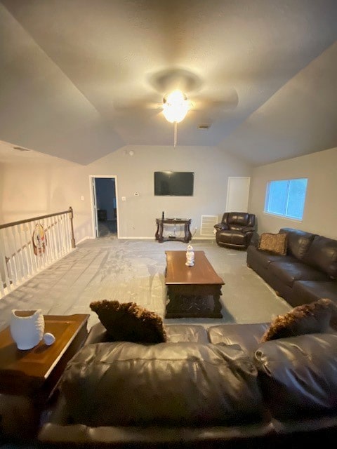 living room featuring ceiling fan, vaulted ceiling, and carpet flooring