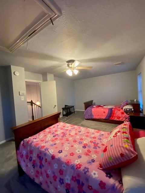 bedroom with a textured ceiling, ceiling fan, and light carpet