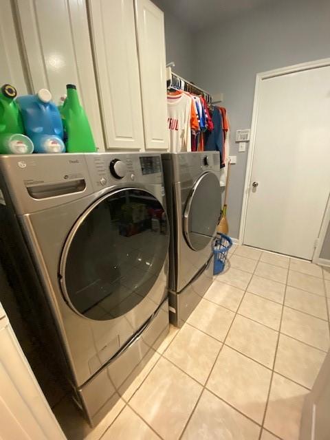 19603 Huckleberry Branch Ct, Spring, TX 77388 - washroom with washer and dryer, tile patterned floors, and cabinet space
