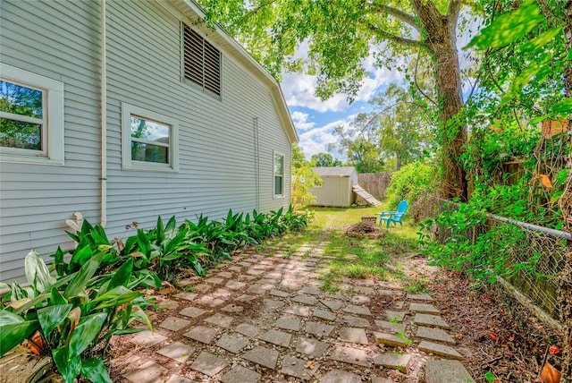 view of yard featuring a storage unit and a patio area